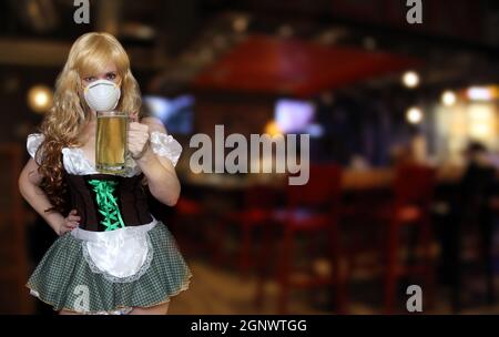 Kellnerin mit N95 Maske halten Bierbecher, flache DOF Fokus auf Bier Stockfoto