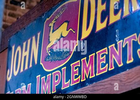 Greenville, Alabama, USA - 24. September 2021: Altes John Deere-Schild hängt im Greenville Hardware Store auf der Commerce Street. Stockfoto