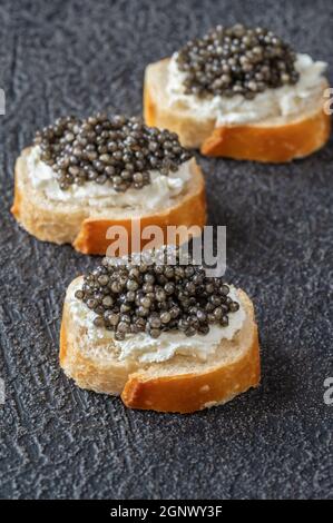 Baguette-Scheiben mit Frischkäse und schwarzem Kaviar Stockfoto