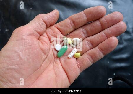 Öffne Hand mit mehreren Tabletten - Symbolbild für Medikamentenabhängigkeit Stockfoto