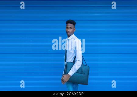 Portrait afroamerikanischer Geschäftsmann in weißem Hemd auf blauem Hintergrund Stockfoto