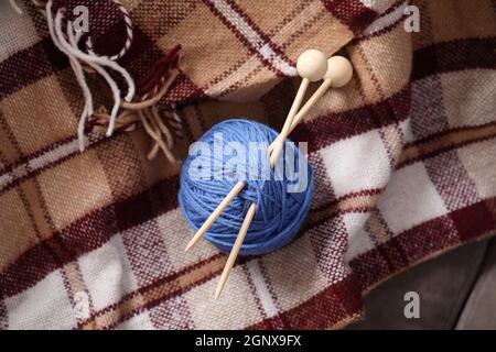 Garnknäuel mit Stricknadeln auf kariertem Kariert Stockfoto
