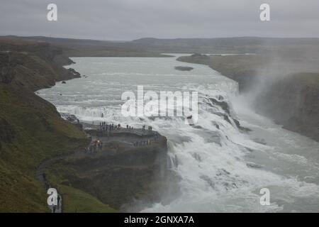 Menschen, die die Kraft des beliebten Touristenziels besuchen und erleben - Gullfoss Wasserfall auf Hvita Fluss in Island. Stockfoto