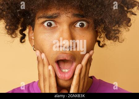 Mann mit lockigen Haaren ist über etwas erstaunt Stockfoto