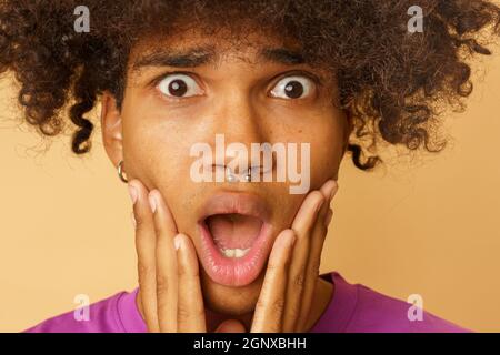 Mann mit lockigen Haaren ist über etwas erstaunt Stockfoto