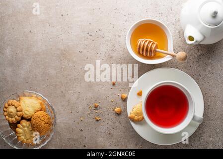 Teetasse mit Früchten, Kräutern und anderen Gewürzen auf grauem Tischhintergrund Stockfoto