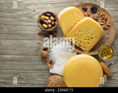Auswahl an Käse, Nüssen und Wein auf Holztisch. Draufsicht. Freier Speicherplatz für Text. Stockfoto