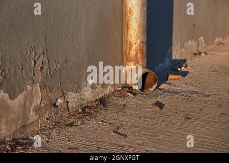 Verwitterte Rinne Kanalrohr auf einer Straße in Sonnenuntergang Licht Stockfoto