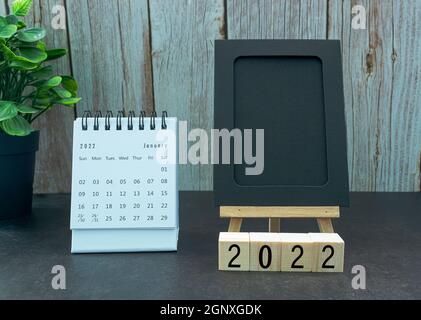 Januar 2022 weißer Kalender mit schwarzem Notizblock und Holzblock - Neujahrskonzept Stockfoto