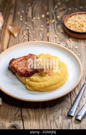 Tschechische Küche, geräuchertes Fleisch mit Erbsenbrei und gebratene Zwiebel bis golden Stockfoto