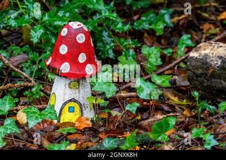 Künstliche kindliche Anzeige einer Fliege agaric rot und weiß Holzhaus Pilz in einem verzauberten Fee toadhocker Wald während Die Herbstsaison Stockfoto