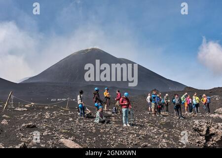 Eine Gruppe von Touristen auf einer geführten Wanderung auf den Ätna, Sizilien, Italien, unter dem derzeit aktiven Südostkrater Stockfoto