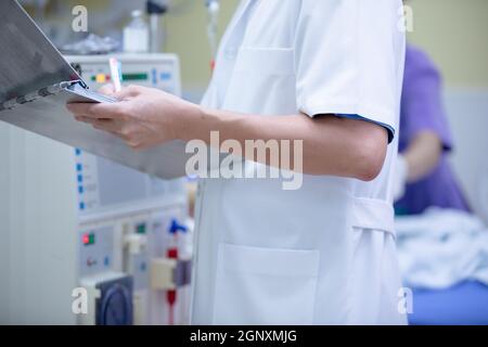 Der Spezialist führt kontinuierliche Nierenersatztherapiegeräte und Injektionspumpen durch. Stockfoto