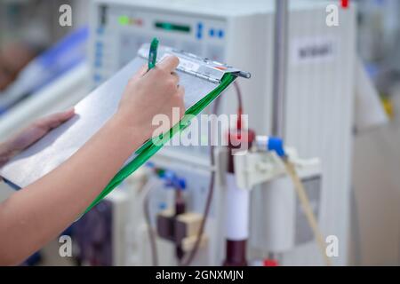 Die Dialysekrankenschwester überprüft das Dialysegerät vor dem Ersatz einer Nierenfunktionsstörung oder Nierenversagen auf der Intensivstation. Stockfoto