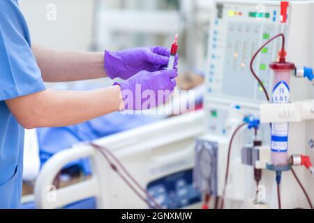 Der Spezialist führt kontinuierliche Nierenersatztherapiegeräte und Injektionspumpen durch. Stockfoto