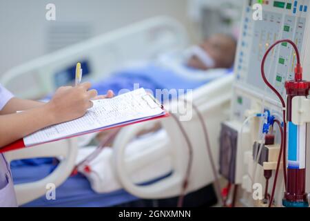 Die Dialysekrankenschwester überprüft das Dialysegerät vor dem Ersatz einer Nierenfunktionsstörung oder Nierenversagen auf der Intensivstation. Stockfoto