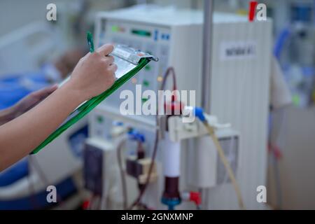 Die Dialysekrankenschwester überprüft das Dialysegerät vor dem Ersatz einer Nierenfunktionsstörung oder Nierenversagen auf der Intensivstation. Stockfoto