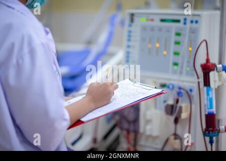 Die Dialysekrankenschwester überprüft das Dialysegerät vor dem Ersatz einer Nierenfunktionsstörung oder Nierenversagen auf der Intensivstation. Stockfoto