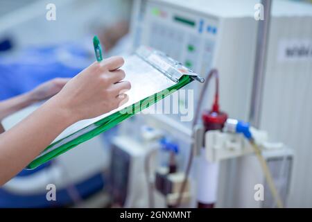 Die Dialysekrankenschwester überprüft das Dialysegerät vor dem Ersatz einer Nierenfunktionsstörung oder Nierenversagen auf der Intensivstation. Stockfoto