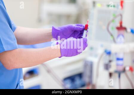 Der Spezialist führt kontinuierliche Nierenersatztherapiegeräte und Injektionspumpen durch. Stockfoto