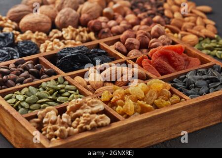 Verschiedene Sorten von Nüssen, Samen und getrockneten Früchten liegen in Holzkiste. Gesunde Ernährung. Vegetarische Ernährung Stockfoto