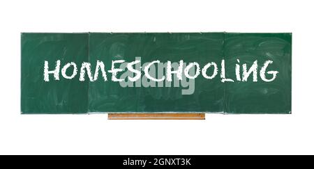 Heimschooling. Wort Homeschooling Schreiben auf alte grüne Tafel isoliert auf weißem Hintergrund Stockfoto