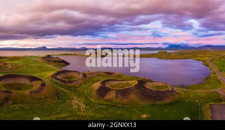 Luftpanorama von Myvatn, Island bei epischem Sonnenuntergang. Vulkanische Krater in Grün krümmungen und verbinden Wolken und Himmel Stockfoto