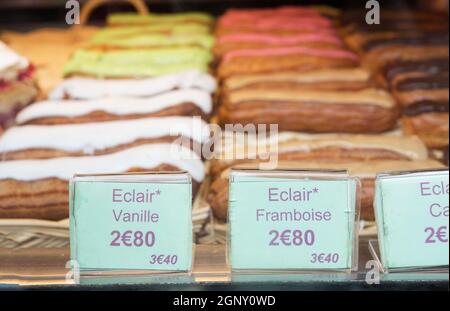 Lokalen Patiserie in Paris zeigt die typisch französisches Gebäck: Eclairs Vanille und Himbeere Stockfoto