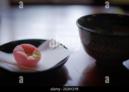 Grüner Tee und Süßigkeiten, die auf dem Tisch im japanischen Stil platziert wurden. Drehort: Metropolregion Tokio Stockfoto