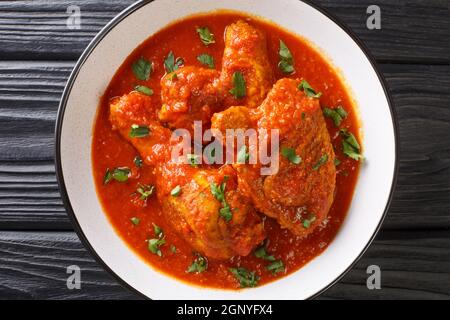 Scharfes Tomatenhuhn Ayam Masak Merah Nahaufnahme in einer Schüssel auf dem Tisch. Horizontale Draufsicht von oben Stockfoto