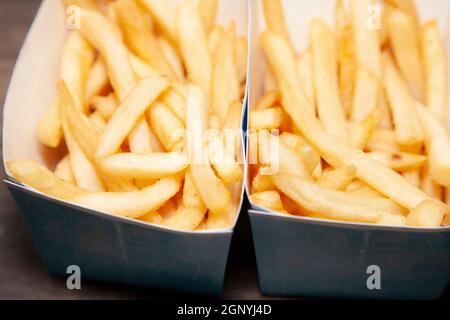 Zwei Päckchen Pommes auf einem Holztisch Stockfoto