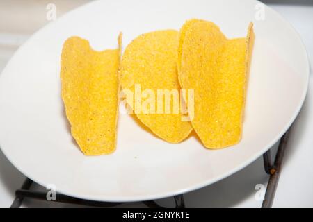 Drei leere Mais-Taco-Schalen auf einem weißen Teller Stockfoto