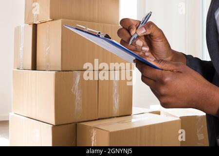 African Courier Delivery Frau Schreiben In Zwischenablage Stockfoto