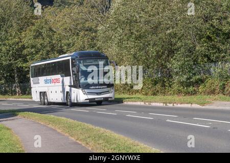 Der National Express von Cornwall nach London fährt bergauf durch die kleine Stadt Lostwithiel in Cornwall. Öffentliche Reisebusse Großbritannien. Stockfoto