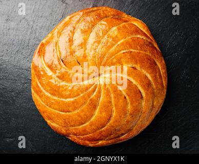 Epiphany Kuchen oder Galette des rois in Französisch auf schwarzem Schiefer Hintergrund Stockfoto