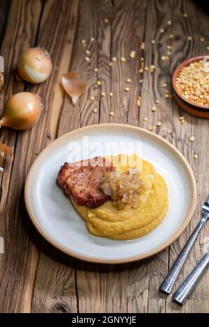 Tschechische Küche, geräuchertes Fleisch mit Erbsenbrei und gebratene Zwiebel bis golden Stockfoto