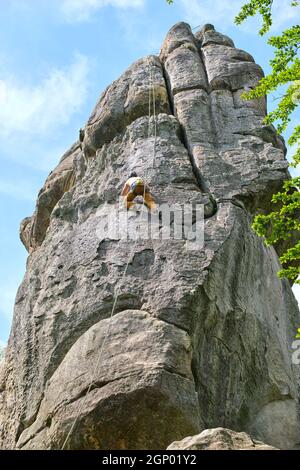 Entschlossener Kletterer, der die steile Wand des felsigen Berges hochklettert. Sportler überwinden schwierige Route. Engagement in Extremsport und Klettern Hobb Stockfoto