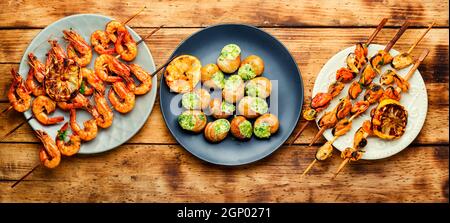 Gegrillte Garnelen und Muscheln auf Holzstäbchen Stockfoto