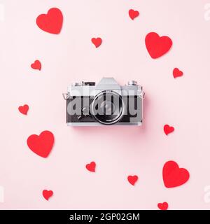 Valentinstag Hintergrund. Vintage retro Kamera und rote Herzen Komposition Grußkarte Liebe Valentinstag Ich liebe Fotografie Konzept auf rosa backg Stockfoto