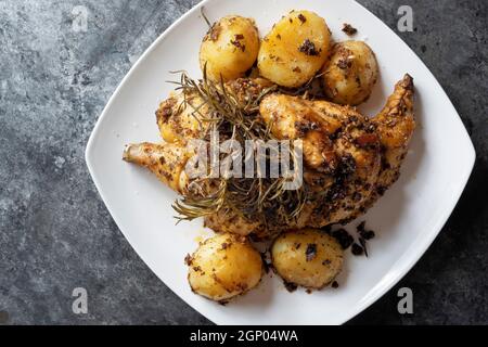 Nahaufnahme von rustikalem, goldgeröstetem Rosmarin-Huhn und Kartoffeln Stockfoto