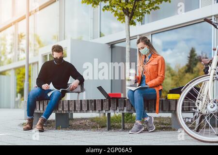 Zwei Studenten lernen, während soziale Distanz auf dem Campus zu halten Stockfoto