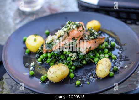 Lachsfilet mit grünen Erbsen und Spinat Stockfoto