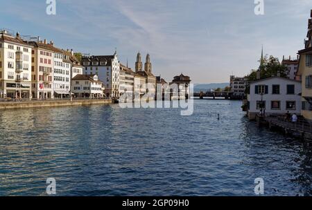 Zürich schweiz Sept. 13 2021: Blick von der Bahnhofsbrücke auf die limmat, grossmünster, rudolf brun Brücke in der warmen Morgensonne, blau Stockfoto