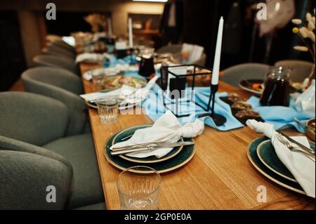 Wunderschön gedeckte Tische mit Essen, Gläsern und Geräten im Restaurant. Stockfoto