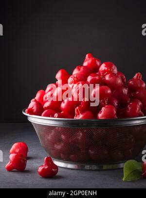 jambu oder Rosenapfel, glockenartige Form Frucht auch Glockenfrucht oder Wachsapfel genannt, Sri lanka saftige Früchte in einem Korb, auf dunklem Hintergrund genommen Stockfoto