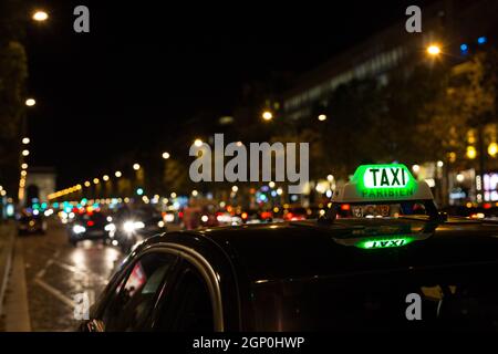 Französische Taxi mit den Champs-Elysées im Hintergrund Stockfoto