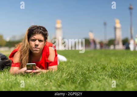 Glückliche Frau in Paris überprüfen ihr Smartphone News Stockfoto