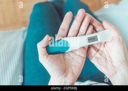 Frau mittleren Alters Hand hält Schwangerschaftstest, Ergebnis ist schwanger, "Schwanger" Stockfoto