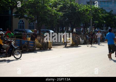 Kambodschanische Arbeiter Menschen schieben ziehen alte Holz Trolley-Wagen Service tragen Waren Produkt in Poipet Grenzübergang und Aranyaprathet in Sa Kaeo in Thailand Stockfoto