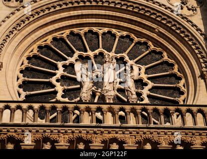 Wunderschöne Rosette mit Ornament der drei Engel an der Westfassade der Kathedrale Notre Dame in Paris, Frankreich an Einem schönen Frühlingstag Stockfoto